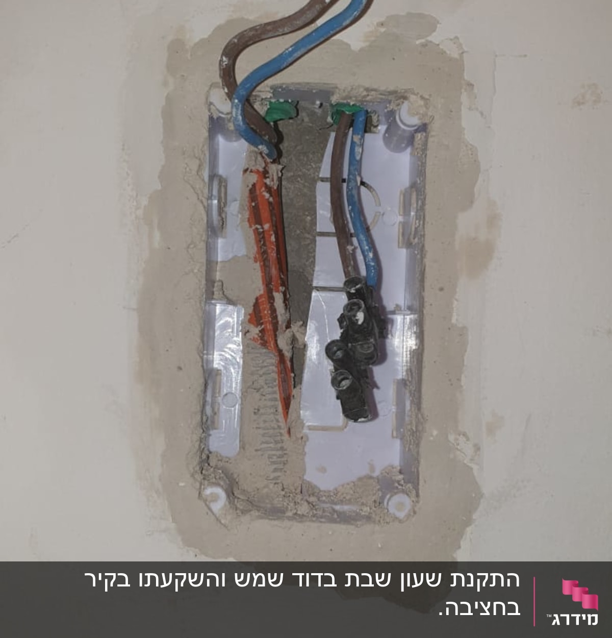 חוטי חשמל חשופים בקופסת חיבורים בקיר